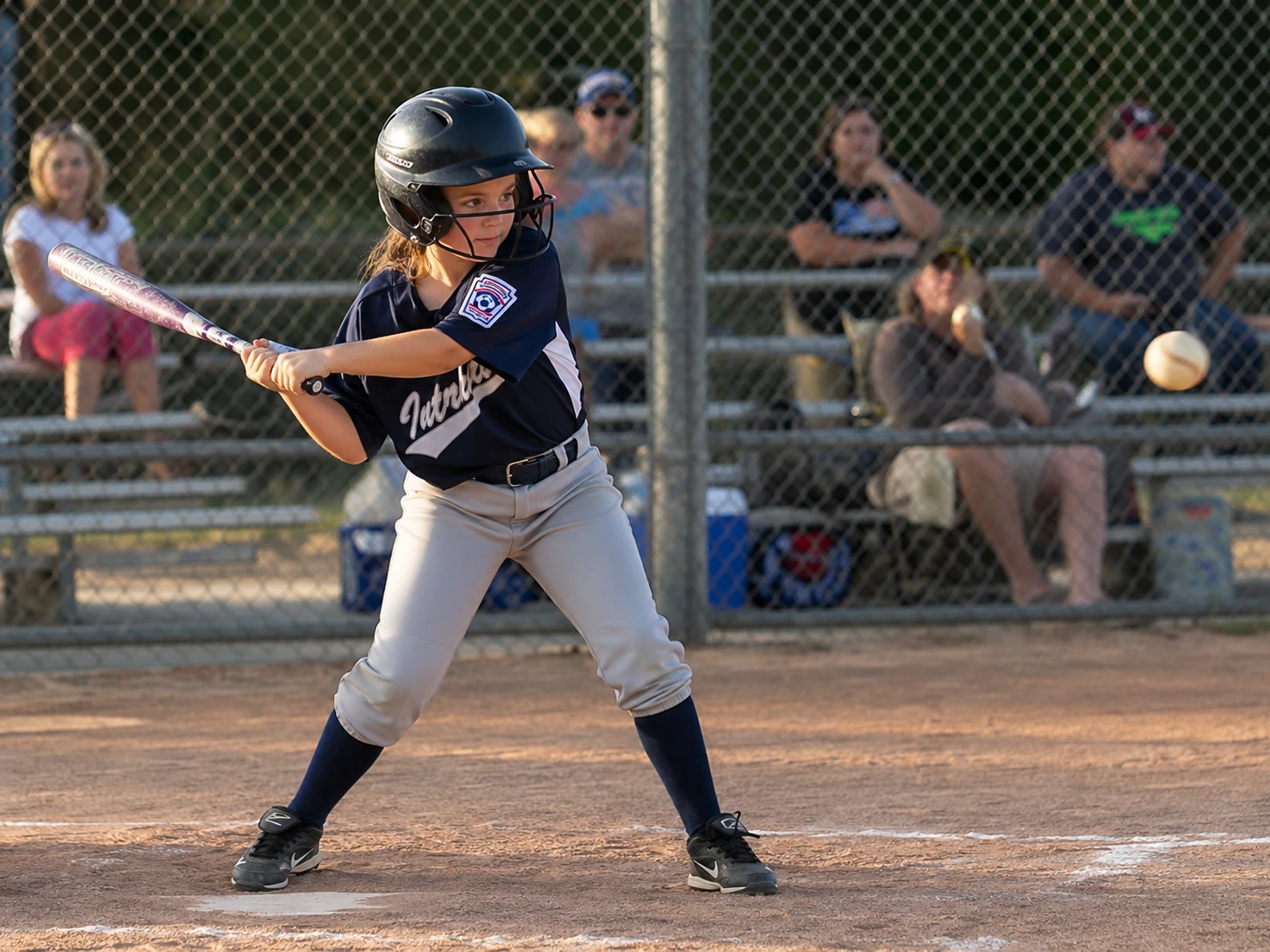 Claire junior batting the ball in little league
