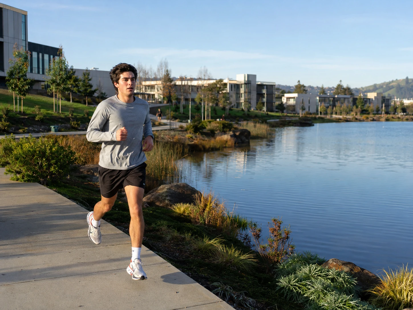Student runner training beside the campus lakes on a clear morning